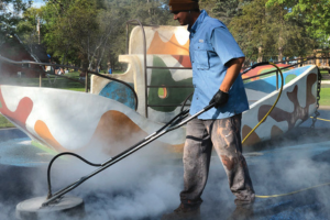 Man cleaning a playground with surface cleaner